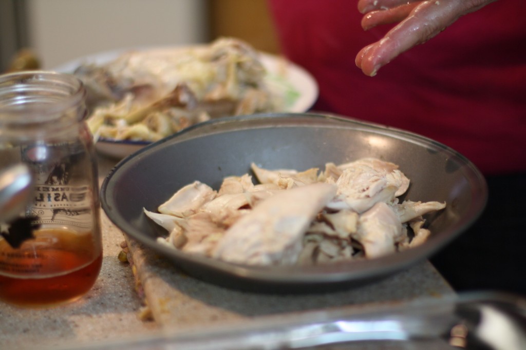 The meat is taken from the chicken carcass and set aside