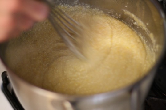 Whisking the grits as they cook is essential